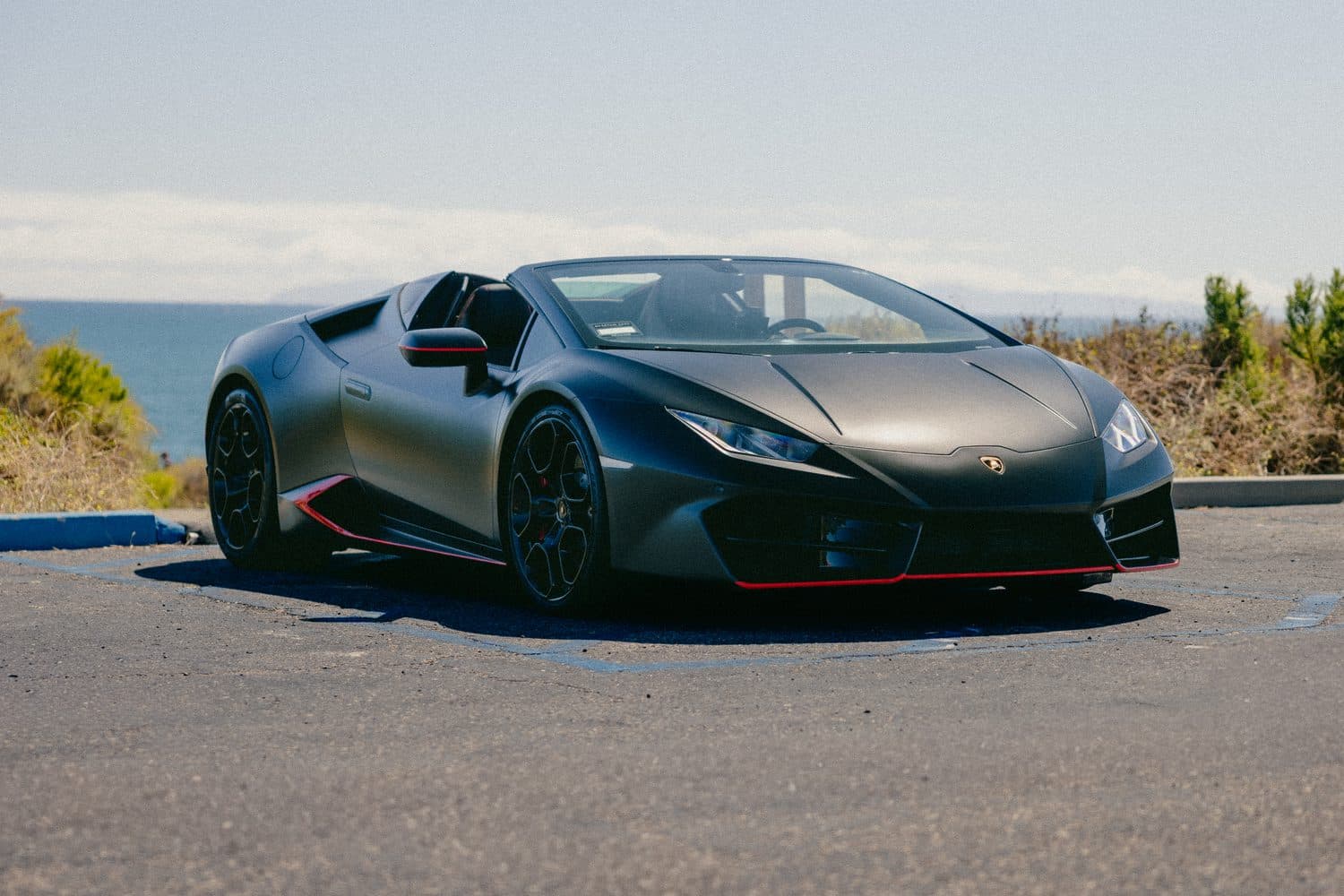 Matte-black Lamborghini Huracán EVO Spyder parked above the Orange County coast