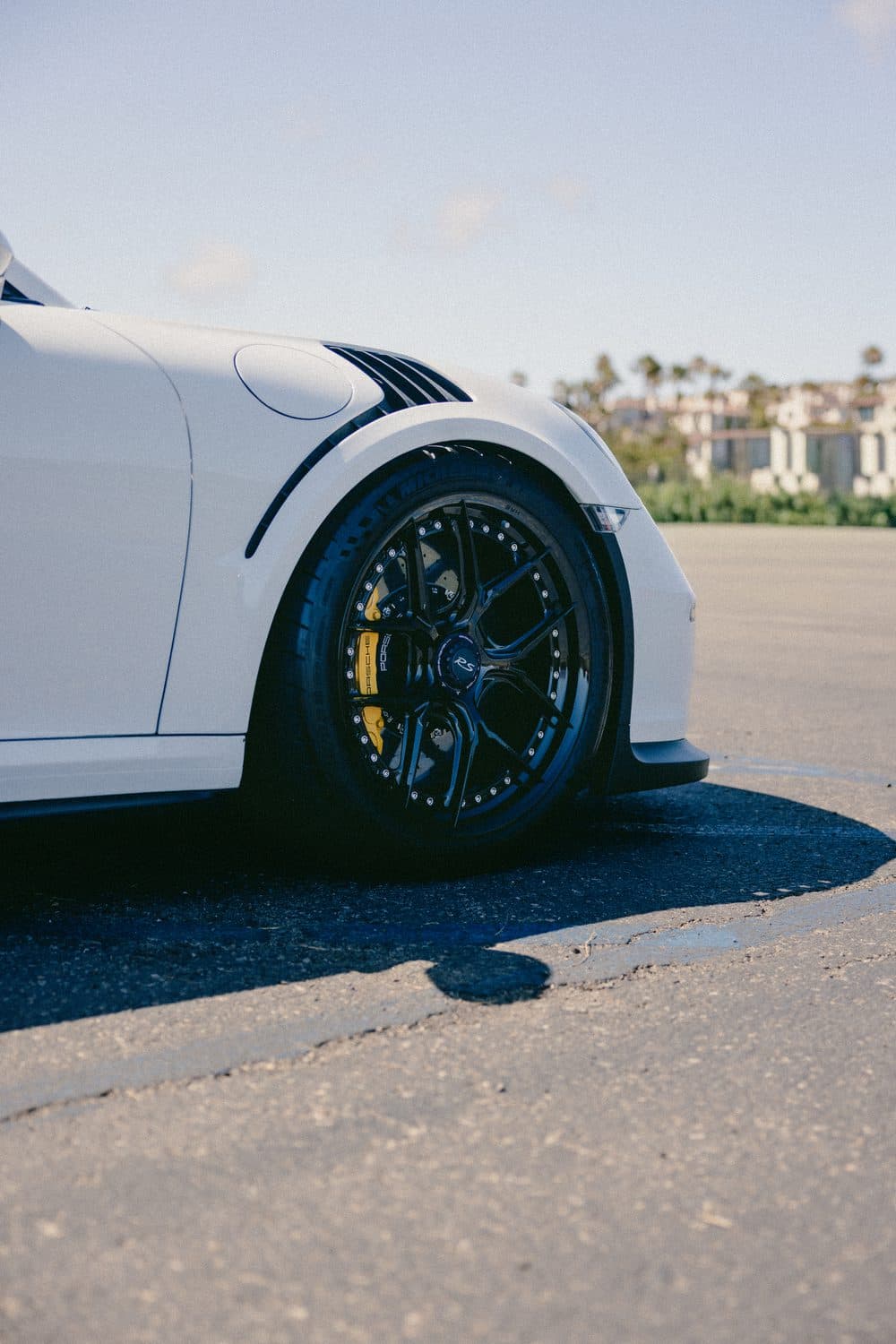 Close-up of the GT3 RS front wheel: black multi-spoke rim, yellow ceramic brake caliper and RS center cap