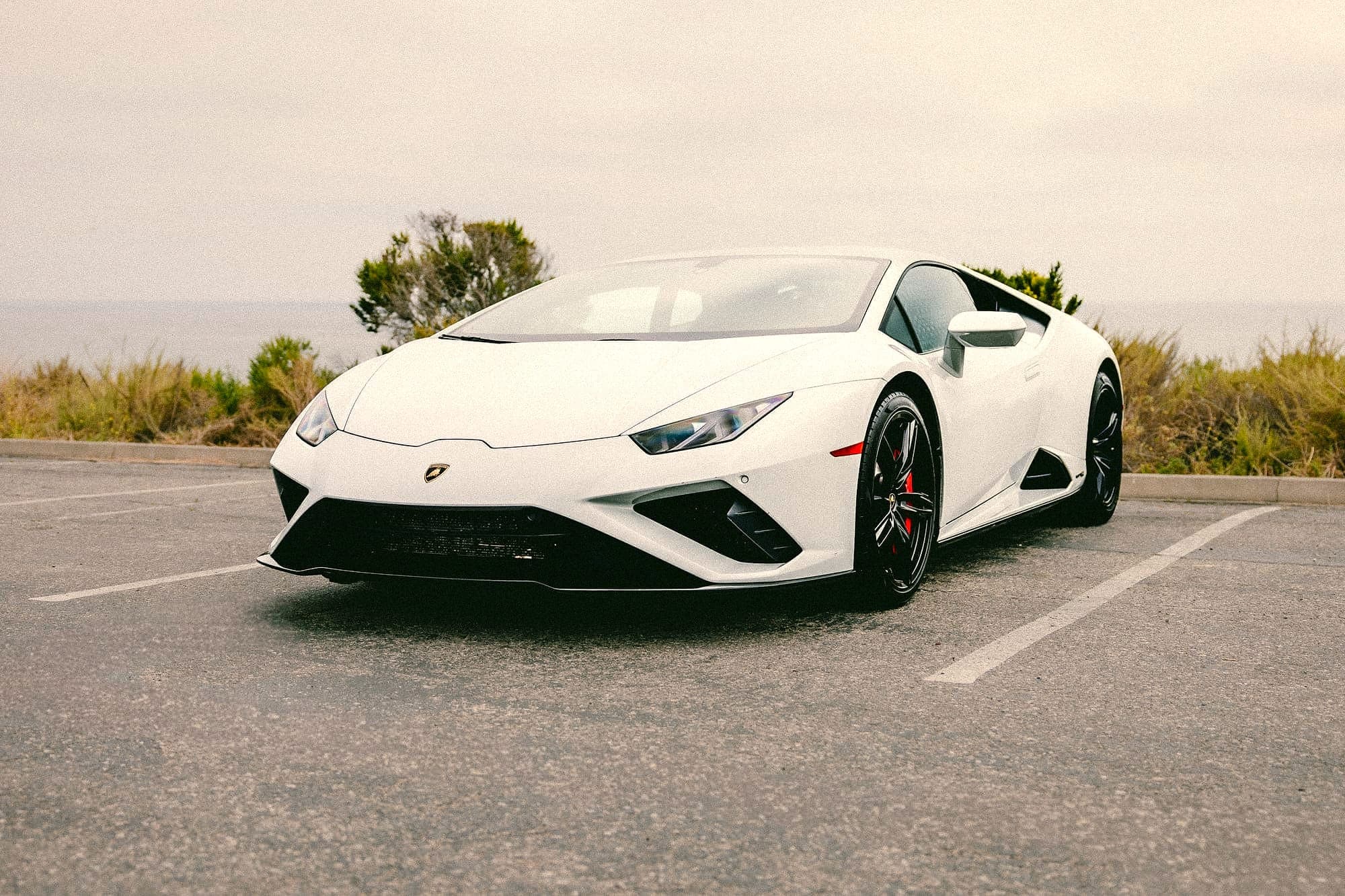 White Lamborghini Huracán parked on a sunlit open lot in Orange County